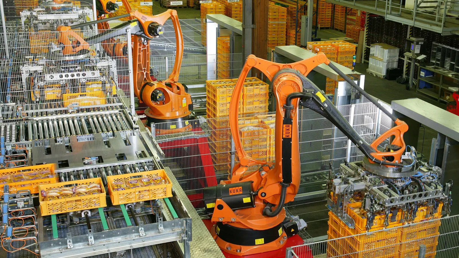 Paletleme hattında çalışan turuncu endüstriyel robot kollar